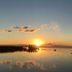 Sunset over calm water at Puerto Valle Hotel De Esteros in Puerto Valle