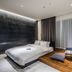 Rivertain Hotel Daegu guest room with bed, wood platform seating area, and floor-to-ceiling curtains