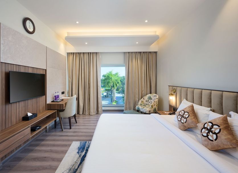 Flora Airport Hotel and Convention Centre Kochi guest room with king bed and balcony view in Kochi