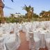 Hotel della Valle in Agrigento: outdoor banquet setup with white-clothed tables and chairs among palms