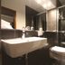 SL'otel Budget Bernburg bathroom with wall-mounted sink, toilet, and glass shower enclosure