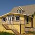 Gîte Au Coin De La Berge in Perce, yellow gîte with wraparound deck and staircase
