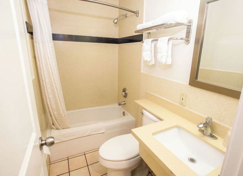 Tropic Lodge bathroom in Garden Grove with tub-shower, vanity, sink, mirror, and toilet