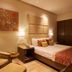 The Gateway Hotel Beach Road, Visakhapatnam guest room with king bed, armchair and wall art