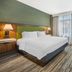 Hampton Inn & Suites Coeur d' Alene guest room with king bed, TV, and window view in Coeur d'Alene