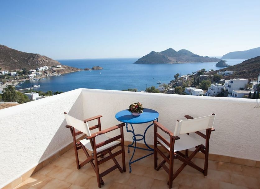 Golden Sun Hotel Patmos terrace with chairs and table overlooking Grikos bay and islands