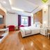 Home Hotel Hanoi guest room with bed, balcony door, vanity desk, wall TV, and red chair