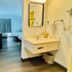 Motel 6 Milford Ct bathroom vanity and mirror leading to a guest room with two beds