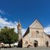 Hotel Pelikan in Schwäbisch Gmünd with a stone church and bell tower under a blue sky