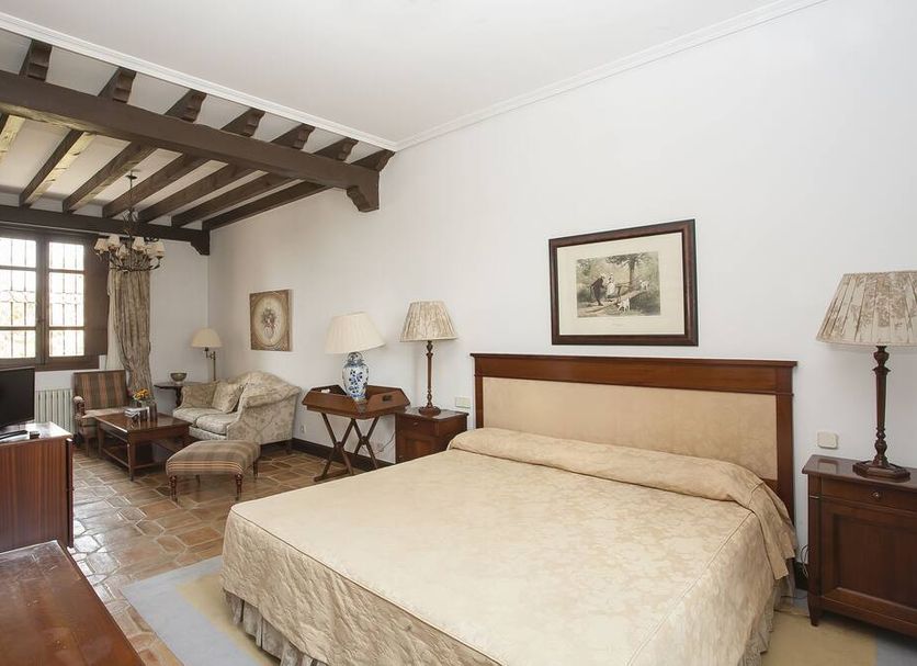 Vettonia in Ávila guest room with bed, exposed wooden beams, seating area and window
