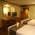 Ao Nang Beach Resort in Krabi guest room with two beds, desk, mirror and TV