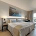 Tyrifjord Hotell in Vikersund guest room with twin beds, balcony doors, seating area and wall-mounted TV.