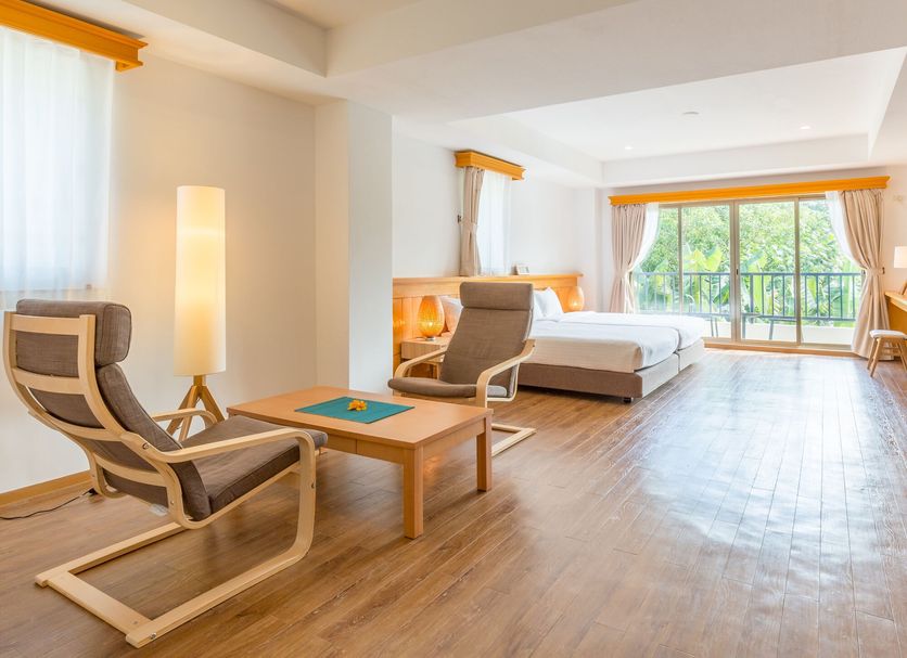 Garden Palace Downtown Koror guest room with king bed, seating area, and balcony view in Koror