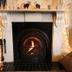 Laston House in Ilfracombe fireplace with lit fire, floral wallpaper, and string lights