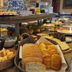 Breakfast buffet at Porto Pacuíba Hotel in Ilhabela with breads, pastries, fruit, and juices.
