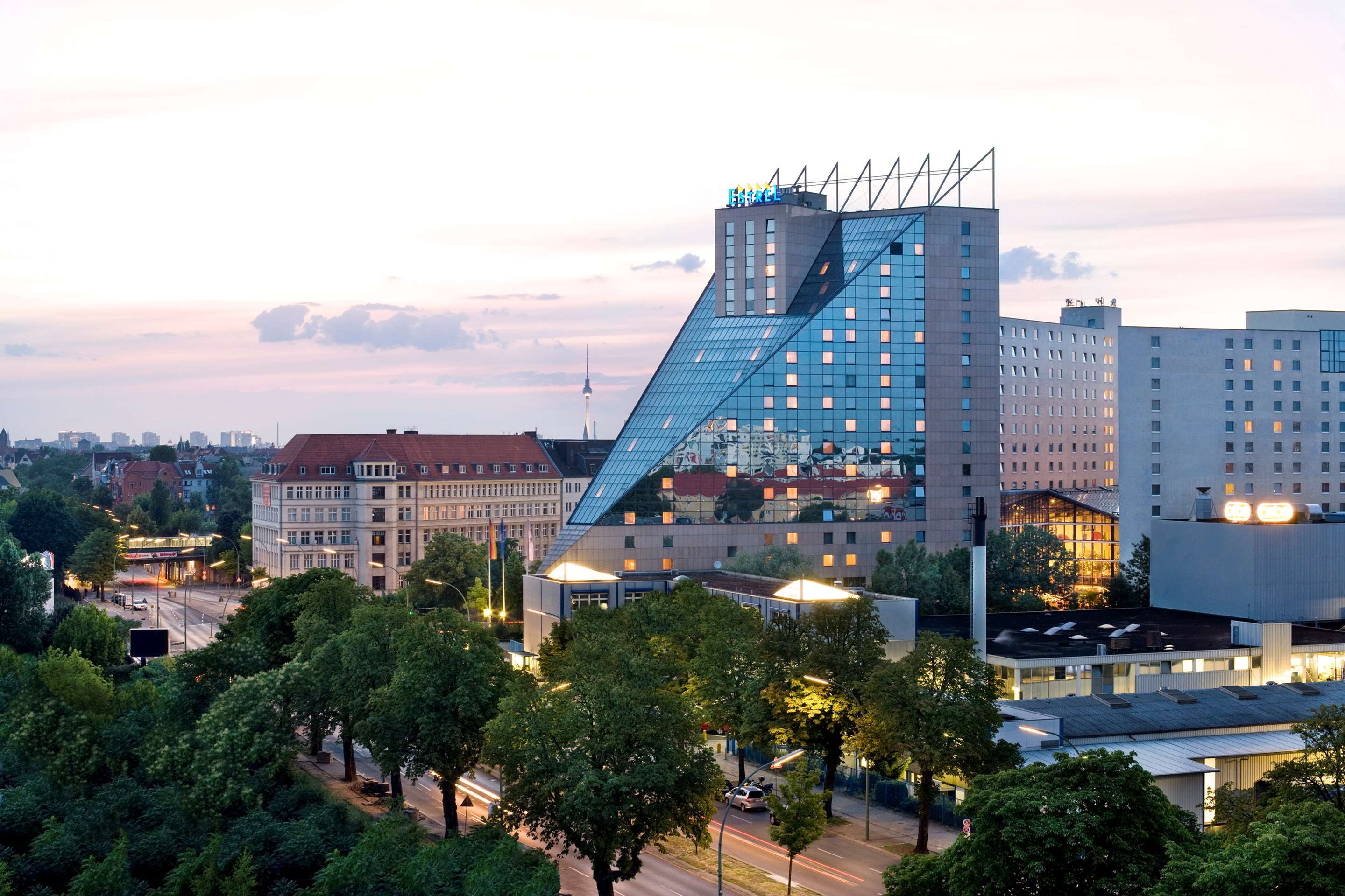 Estrel Hotel Berlin in Berlin with a distinctive glass facade and city view at dusk