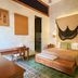 Ya'ax Hotel Boutique in Mérida with a bed, green tile floor, and a decorative wall hanging