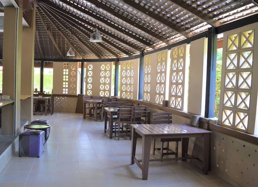 B Square Hotel at Khanom open-air dining area with wooden tables and lattice windows
