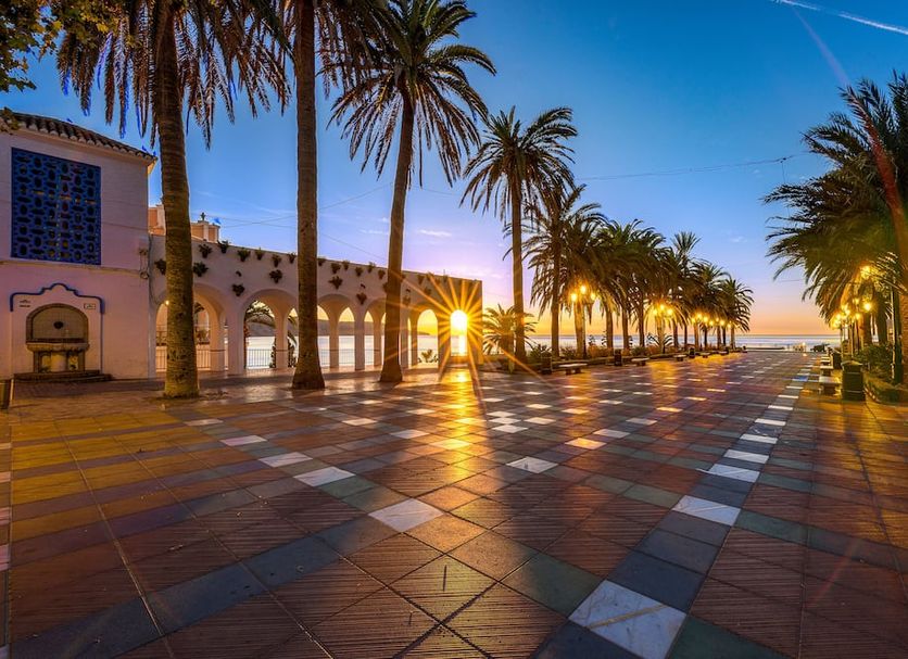 Sibarys Hotel Boutique in Nerja, palm-lined terrace at sunset with ocean views