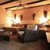 Mount Etjo Safari Lodge in Kalkfeld: rustic lounge with wicker chairs, low table, and arched doorway