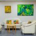 Sarges Hotel, Serrekunda lounge with white chairs, sofa, coffee table and colorful wall art