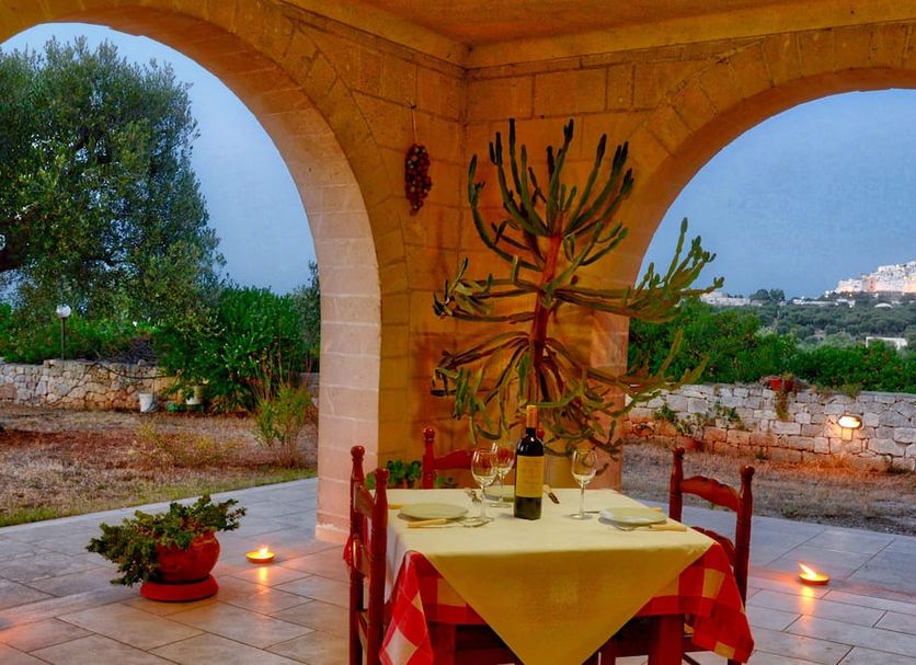 La Piana degli Ulivi in Ostuni: covered terrace dining table with countryside and distant town views