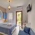 Hotel Agnadi room in Chorefto with double bed, blue accents, balcony door and sofa