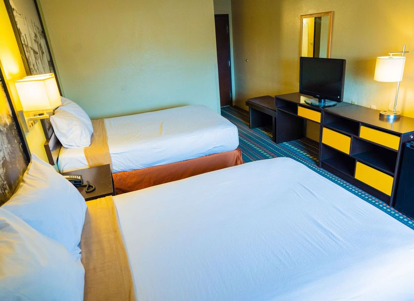 Super 8 by Wyndham Belen NM guest room with two double beds, TV, desk, and lamps