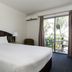 The Waterloo Bay Hotel in Brisbane room with king bed and balcony view to palm trees