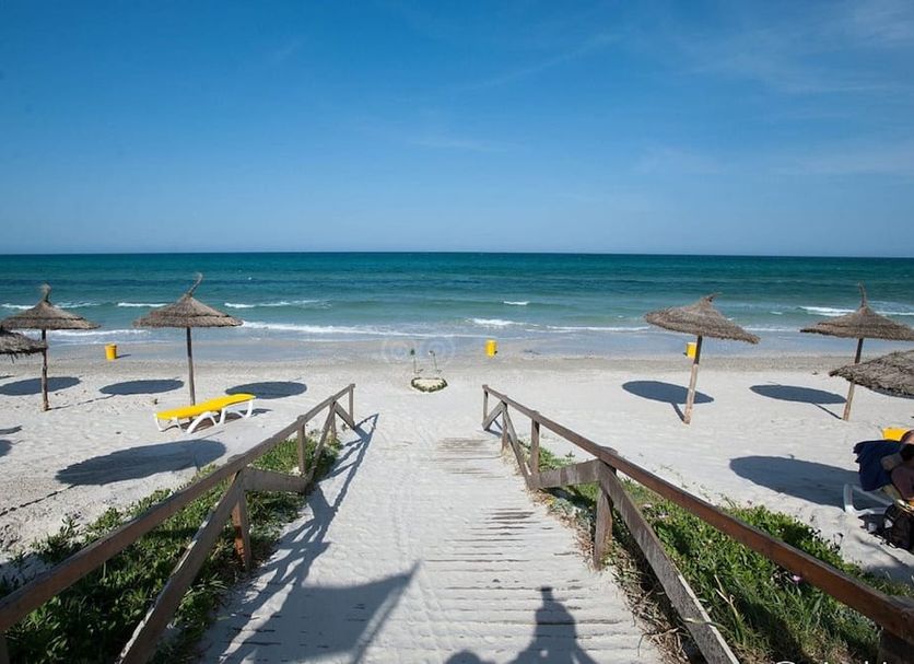Nour Palace Resort And Thalasso Mahdia beach access with steps to sandy shore and sea umbrellas