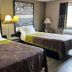 Super 8 by Wyndham Knoxville guest room with two beds, bedside lamps, and racing car wall art