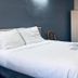 Century 21 Motel Las Cruces room with white bed, blue accent wall and wardrobe