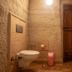Seven Rock Cave Hotel in Göreme bathroom with wall-mounted toilet and wooden door in a cave-style room