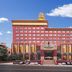 Wanhao International Hotel in Benxi, red-and-gold facade with central entrance and parked cars