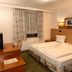 Yeti City Hotel Saarbrücken room with twin beds, desk, window with curtains, and TV