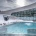 Ecrin Blanc Resort Courchevel Aquapark outdoor pool with snowy terrace and curved glass facade in Courchevel