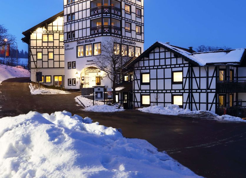 Dorint Resort Winterberg in Winterberg, a chalet-style hotel lit at dusk with snow-covered grounds