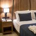 Extenso Hotel in Izmir guest room with wood-paneled walls, king bed, bedside lamps, and folded towels