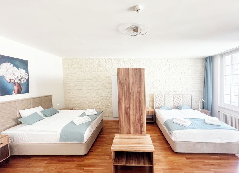 Zunfthaus zu Wirthen in Solothurn guest room with two beds, wood floors, and window light