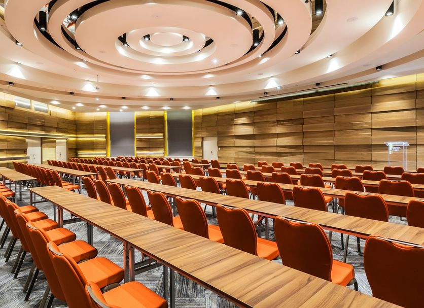 Danubius Hotel Helia in Budapest conference room with rows of orange chairs and long tables