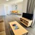 Caloundra Central Apartment Hotel in Caloundra: apartment living room with sofa, TV, dining table and wood floors