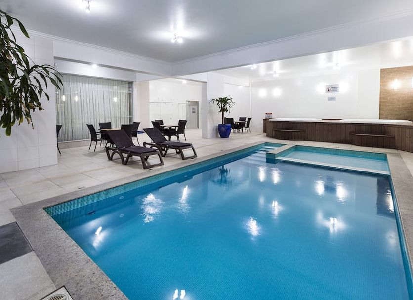 Indoor pool at Hotel Bella Camboriú in Balneário Camboriú with lounge chairs and seating area