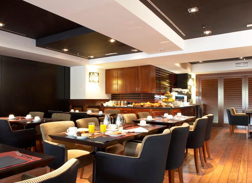 U232 Hotel Barcelona restaurant with set tables, dark chairs, wood flooring, and buffet counter