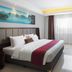 d'primahotel Kualanamu Medan bedroom with king bed, TV, chair, and large window in Medan