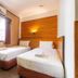 Sipadan Inn 1 Semporna twin room with two single beds, window, and wood-paneled accent wall