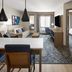 Candlewood Suites Williamsport suite with kitchenette, seating area, desk and bedroom view