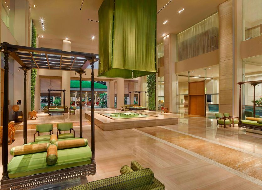 ITC Gardenia, a Luxury Collection Hotel, Bengaluru lobby with green swing seating and indoor garden