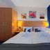 Elbbrücken Hotel Hamburg room with twin bed, wardrobe, bedside lamps and blue curtains