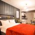 Taks-Inn Suites Istanbul guest room with bed, orange throw, kitchenette and dining table