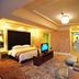 Dalian Jinbai International Hotel room in Dalian with king bed, sofa, TV, and warm lighting